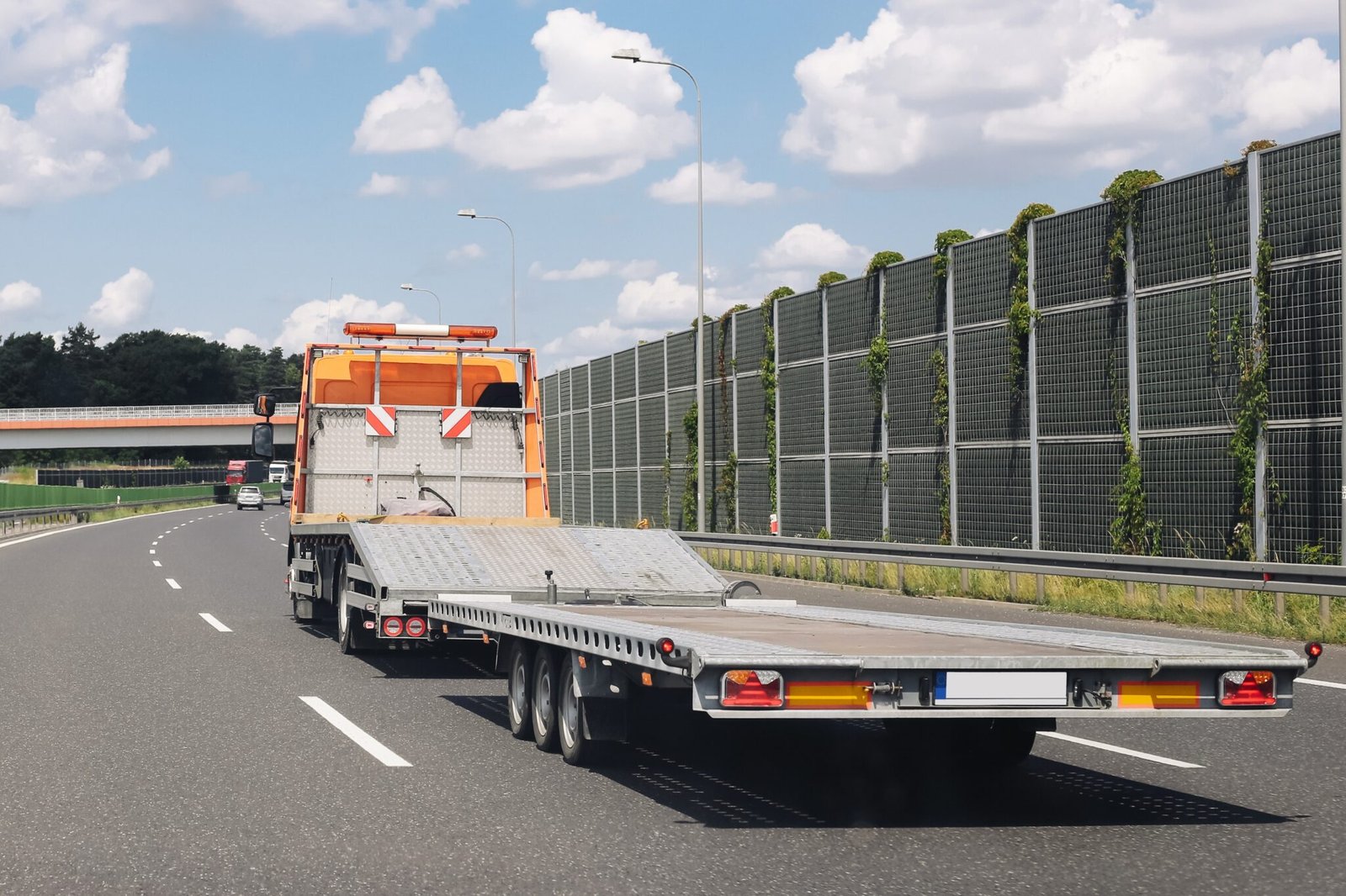 Empty,Tow,Truck,Platform.,Orange,Roadside,Recovery,Vehicle,Driving,On